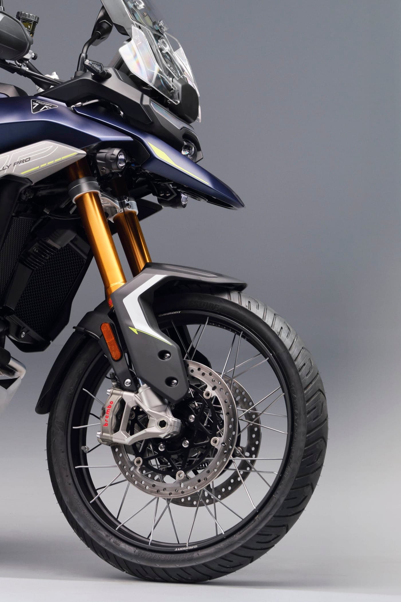 Frente da nova Triumph Tiger 900 Rally Pro com bico azul, garfo dourado, pinça Brembo e roda raiada